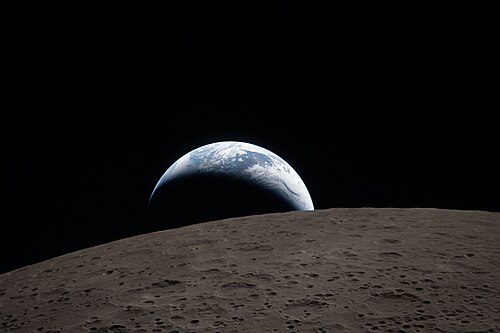 I could describe the picture myself, but the Wikipedia summary’s got lots more fun details than I coulda ever come up with, so I’ll just quote it here: “A muted blue Earth with bright white clouds sets behind the cratered lunar surface. The dark portion of Earth is experiencing nighttime. On Earth's day side, swirling clouds are visible over the Australia and Oceania region. In the foreground, Ohm crater has terraced edges and a flat floor interrupted by central peaks. Central peaks form in complex craters when the lunar surface, liquefied on impact, splashes upwards during the crater's formation.”